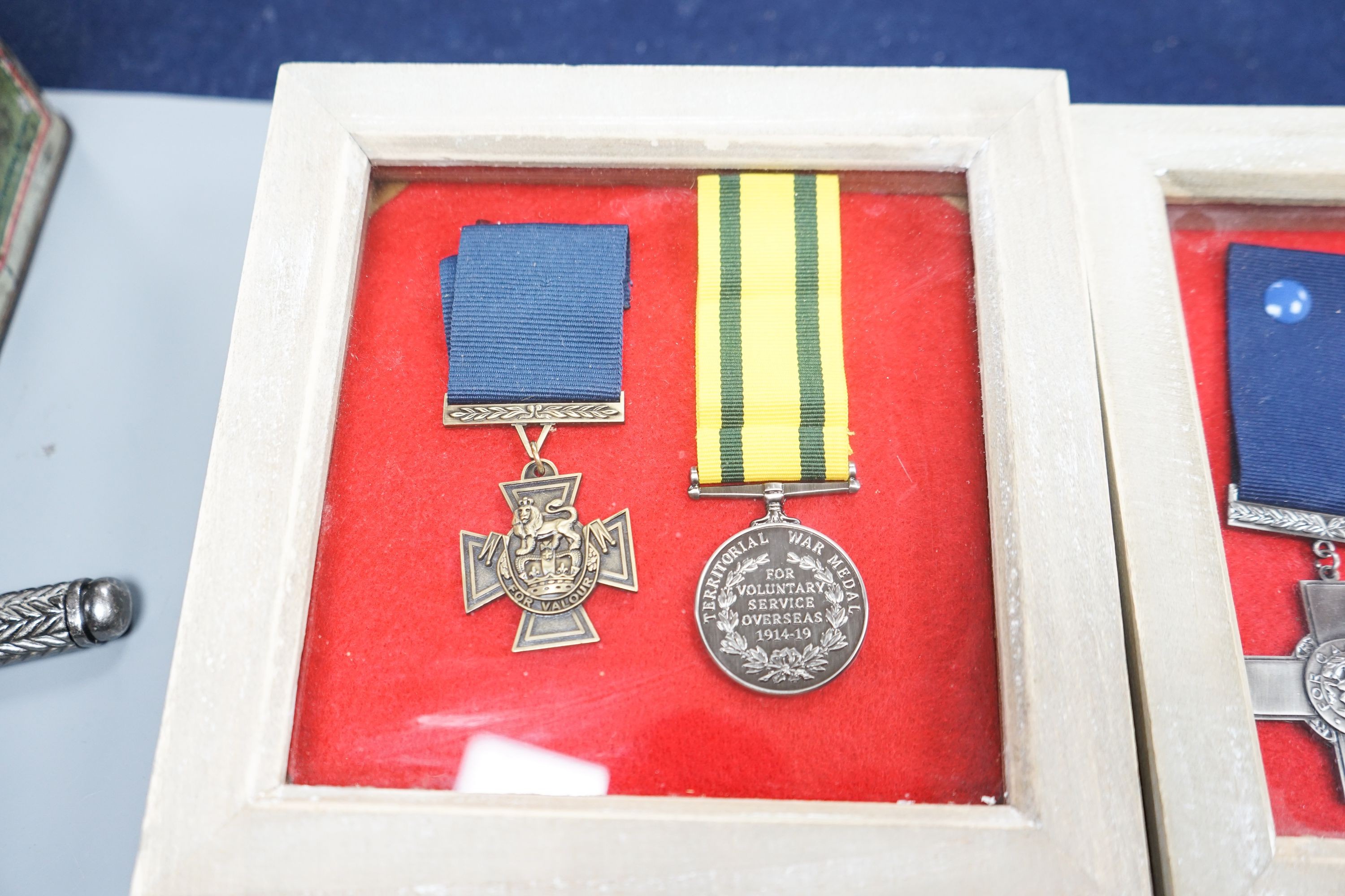 A Canadian First War Christie Brown and Co printed biscuit tin, framed medals, a trench art brass cigarette case and a reproduction German dagger.